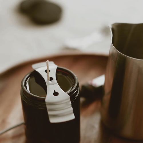 Video of an amber candle jar being poured by hand from a stainless steel pitcher