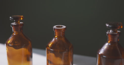 Close up video of three amber fragrance oil bottles