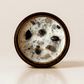 Protection ritual candle with black tourmaline, smoky quartz, obsidian, and botanical details viewed from above.