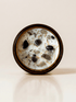 Protection ritual candle with black tourmaline, smoky quartz, obsidian, and botanical details viewed from above.