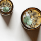 Top view of Release ritual candles with green calcite, quartz, and botanicals.