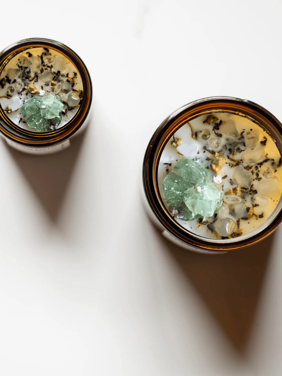 Top view of Release ritual candles with green calcite, quartz, and botanicals.