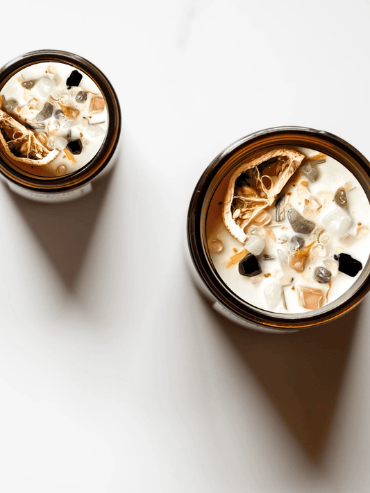 Top view of Renewal ritual candles with moonstone, black tourmaline, rutilated quartz, and botanicals.