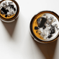 Top view of Retrograde ritual candles with sunset sodalite, fluorite, rutilated quartz, and botanicals.