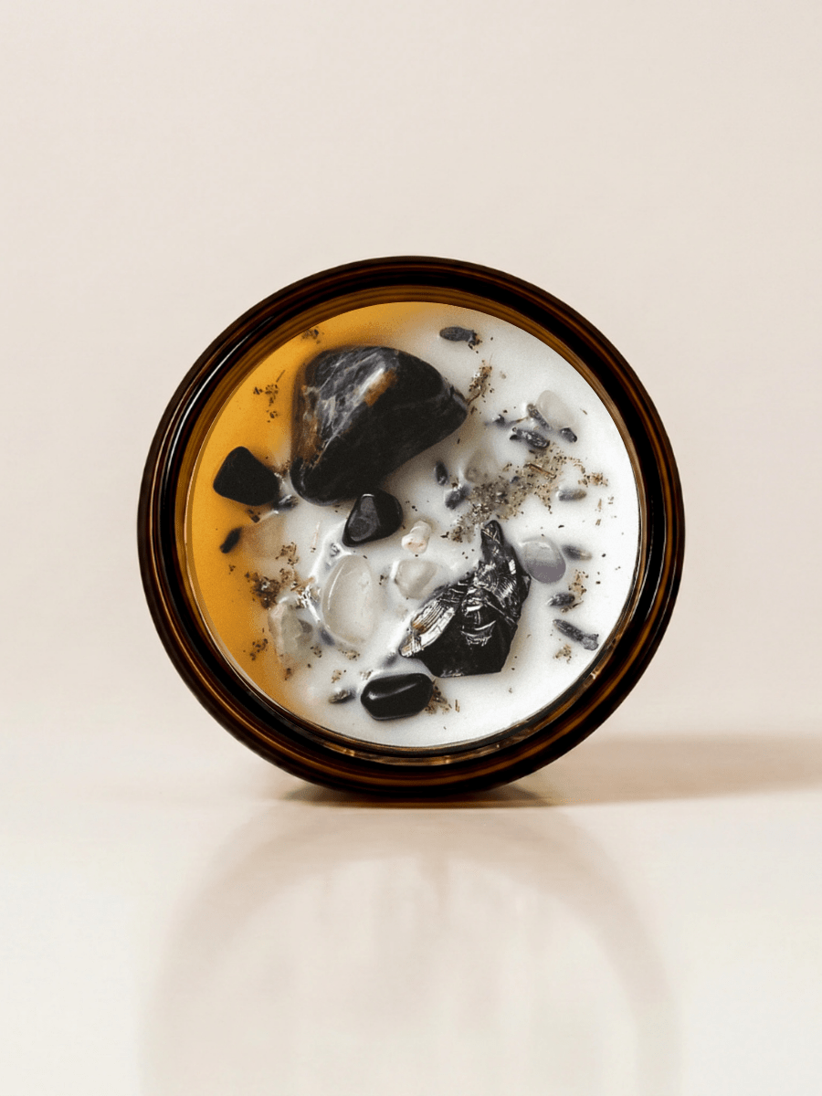Retrograde ritual candle with sunset sodalite, fluorite, rutilated quartz, and botanical details viewed from above.