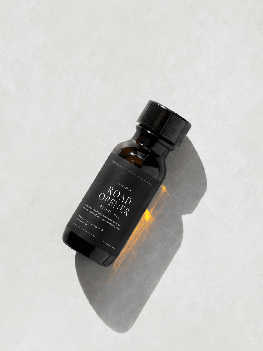Bottle of "Road Opener" ritual oil on a light gray background.