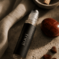 Roll-on bottle labeled Root Chakra Balancing Roller by Alchemist + Co.  on a textured surface with natural elements.