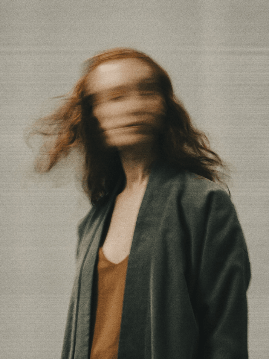A Sagittarius woman in motion against a neutral background.