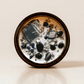 Shadow Work ritual candle with black moonstone, obsidian, sodalite, quartz and botanical details viewed from above.