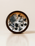Shadow Work ritual candle with black moonstone, obsidian, sodalite, quartz and botanical details viewed from above.