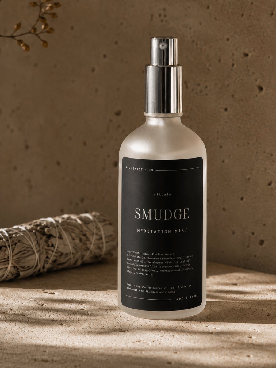 Bottle of 'Smudge' meditation mist on a wooden surface with a blurred background.