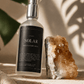 Solar Meditation Mist by Alchemist + Co on travertine stone in warm directional sunlight.