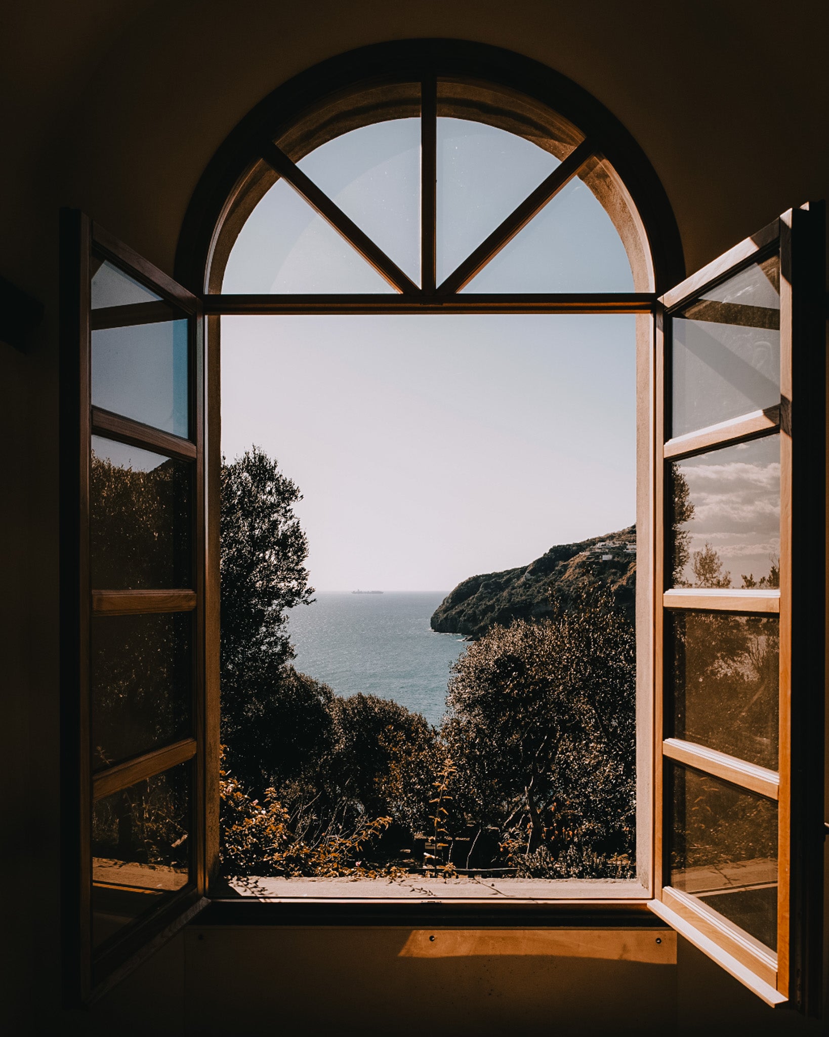 Open window with a view of a coastal landscape