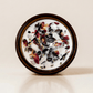 Tantra ritual candle with garnet, rose quartz, quartz, and botanical details viewed from above.