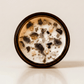 The Alchemist ritual candle with crystals, frankincense resin, and botanical details viewed from above.