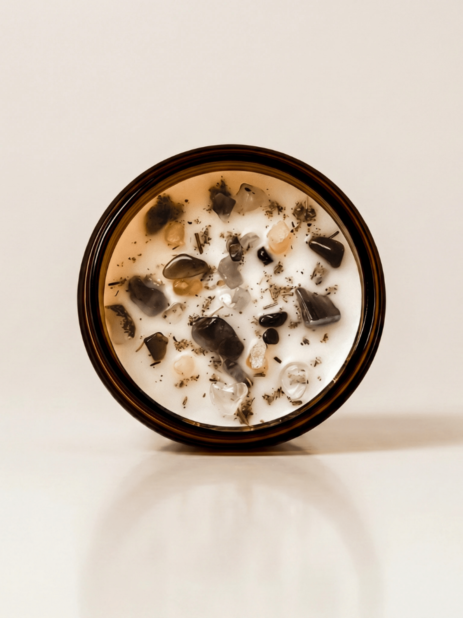 The Alchemist ritual candle with crystals, frankincense resin, and botanical details viewed from above.