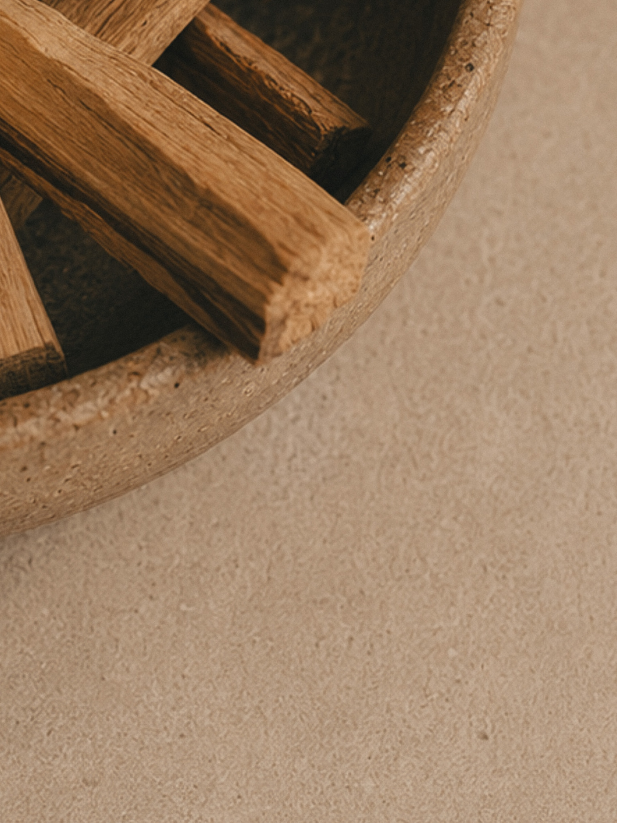 Close-up of Palo Santo sticks in a ceramic bowl on a beige surface