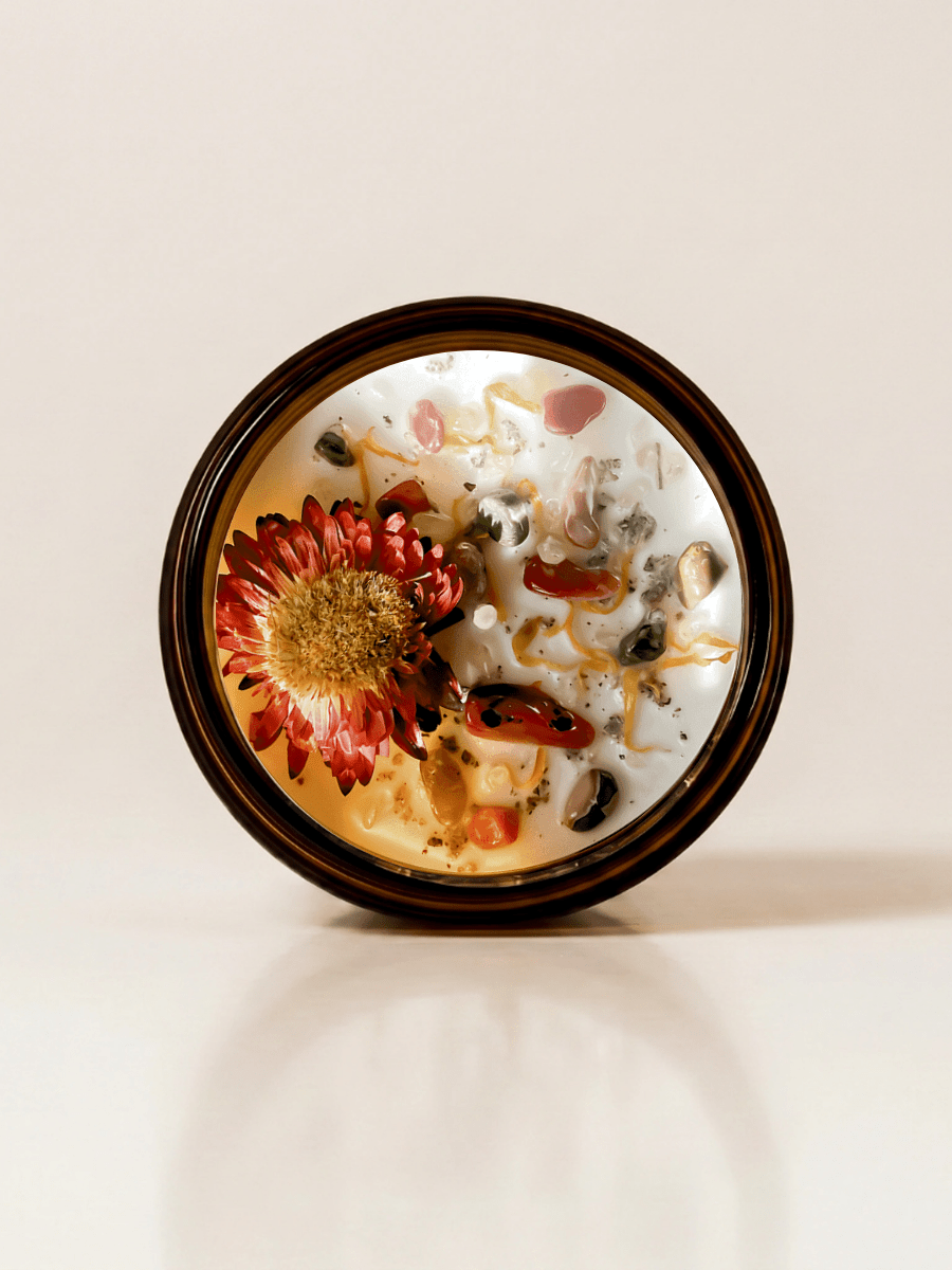 XIX. The Sun ritual candle with carnelian, rainforest rhyolite, citrine, quartz, and botanical details viewed from above.