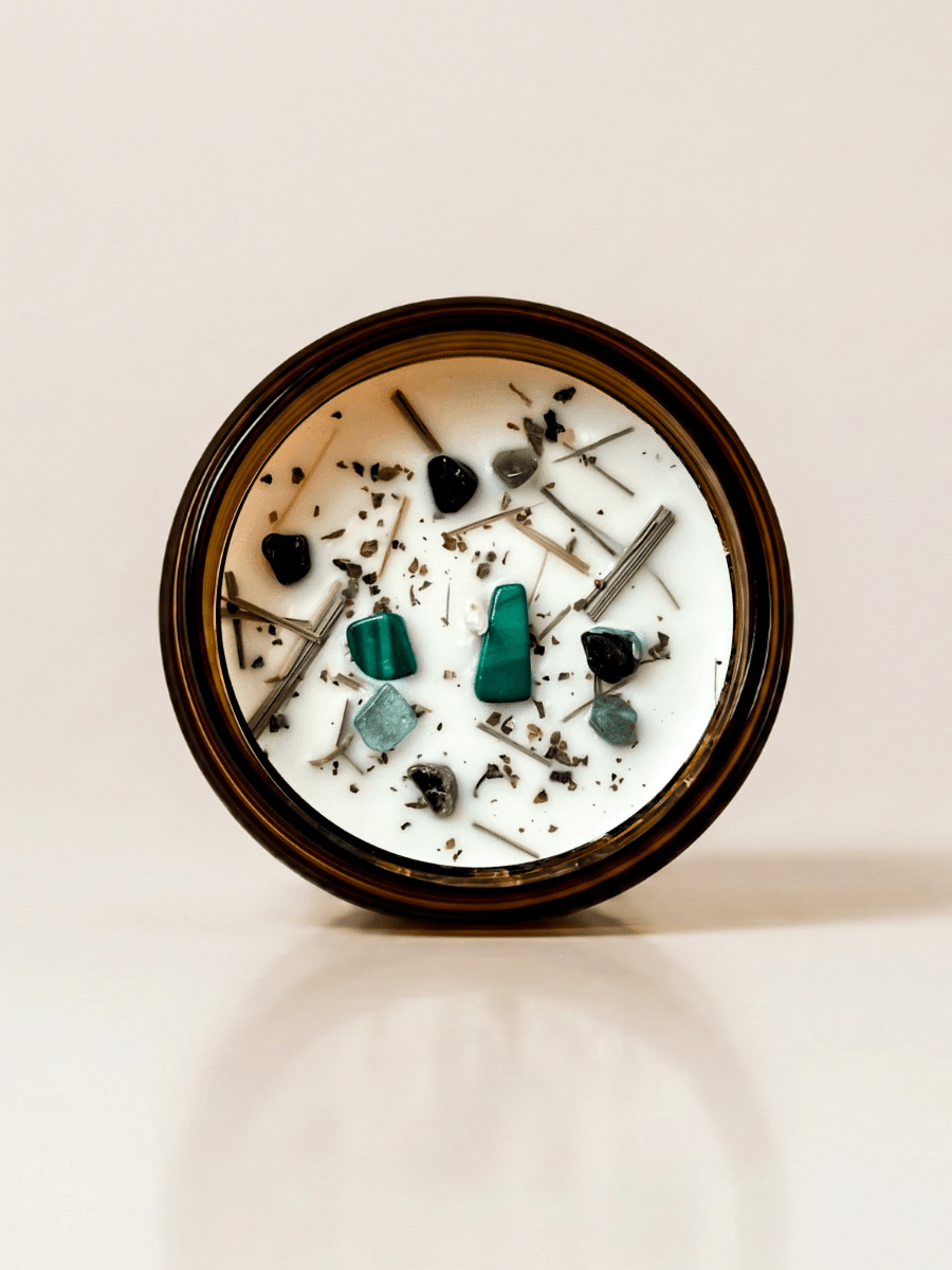Zen ritual candle with malachite, black tourmaline, and botanical details viewed from above.